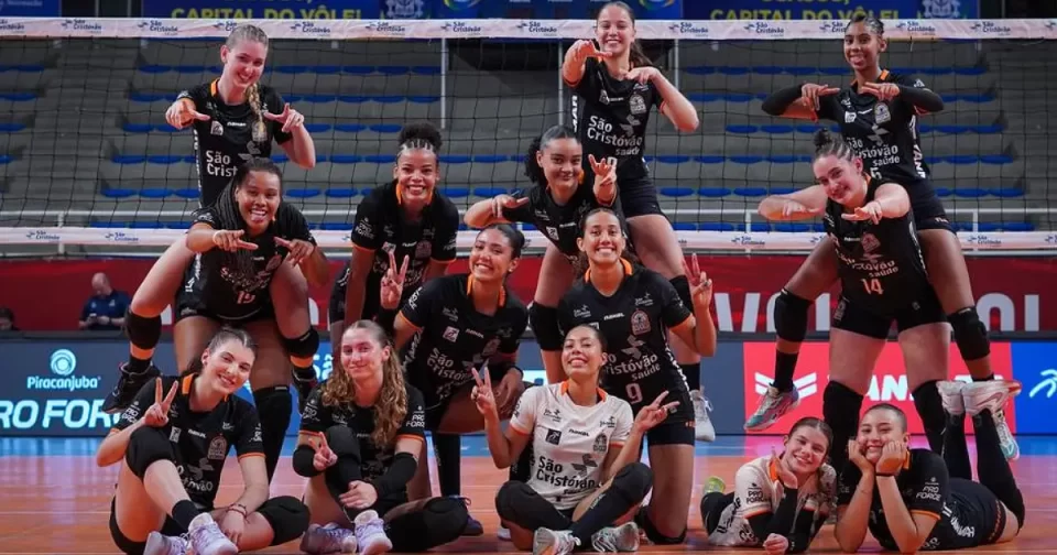 Jogadoras de vôlei com poses divertidas na quadra de um ginásio.
